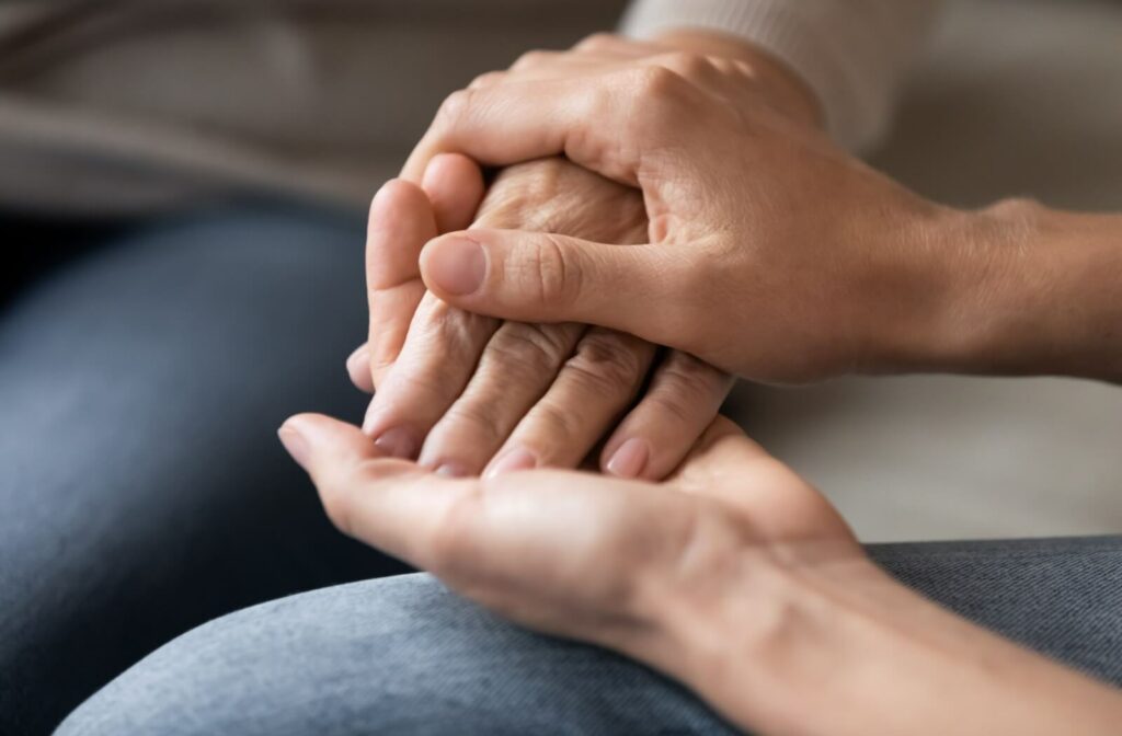 Close-up of a young person holding the hand of an older woman