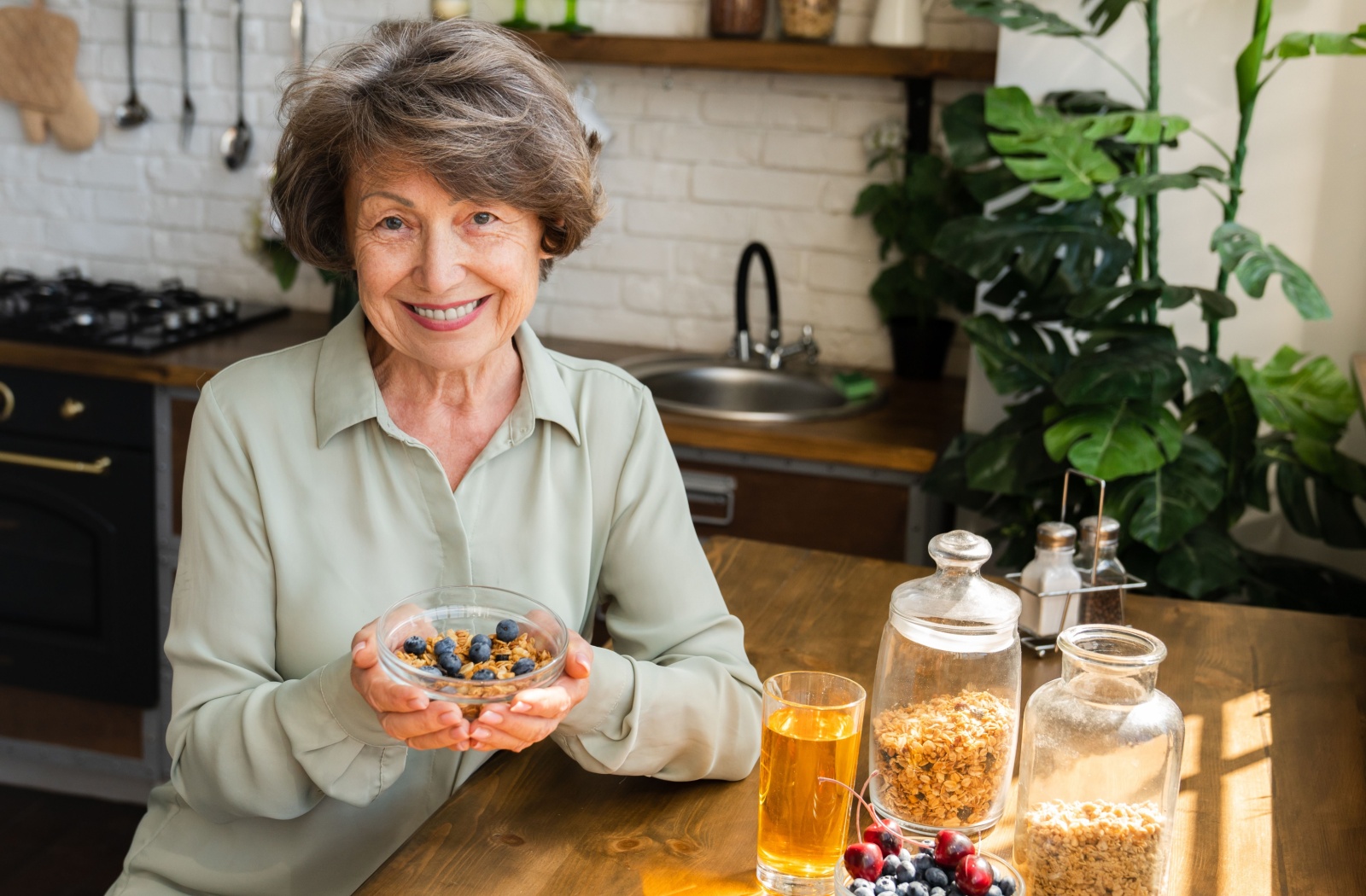 A smiling senior shows off their balanced, heart-healthy breakfast of oats, berries, and Greek yogurt.